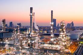 Oil refinery skyline with smokestacks at dusk